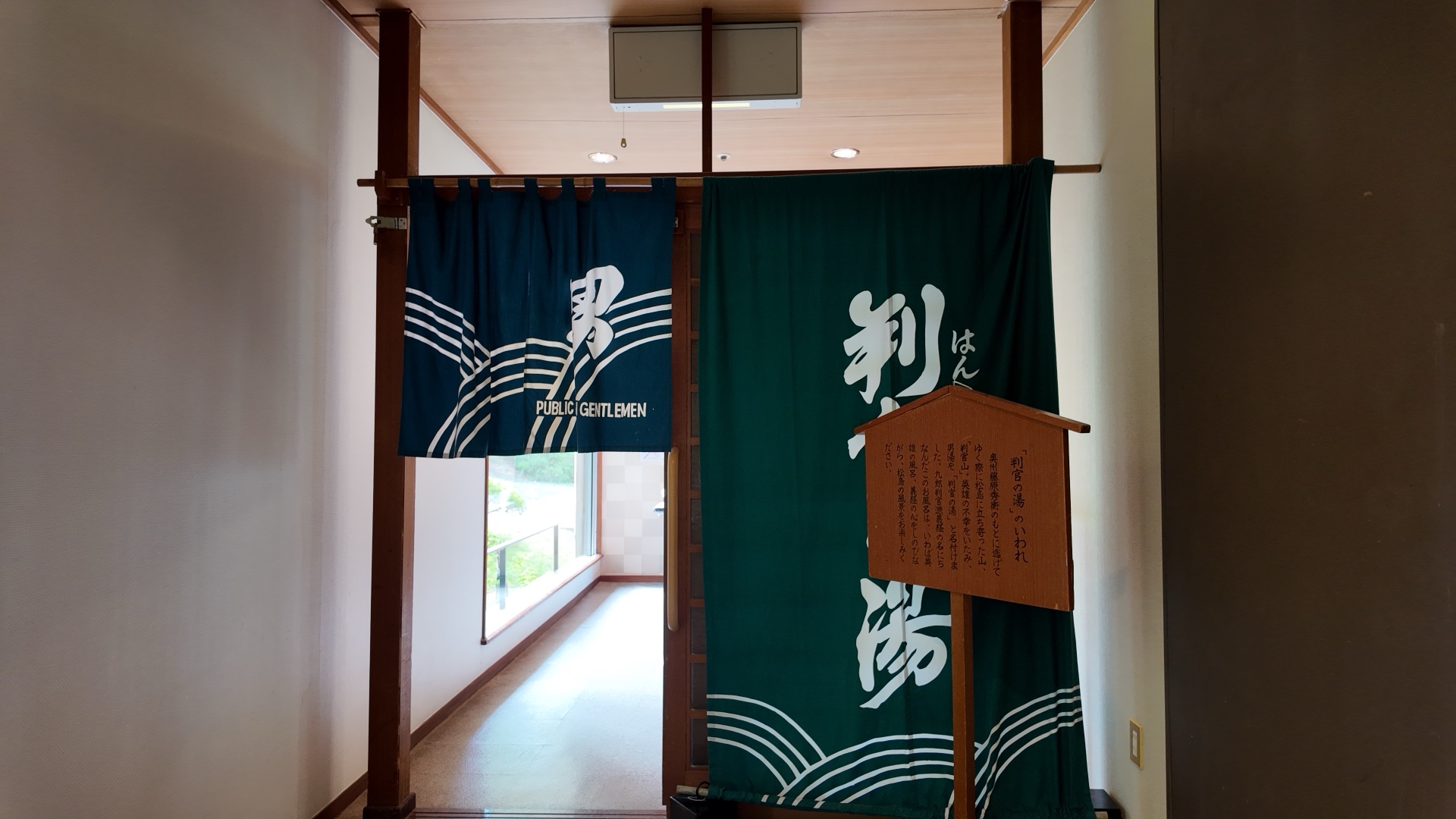 大浴場「判官の湯」の入口。男女それぞれの暖簾が並ぶ
