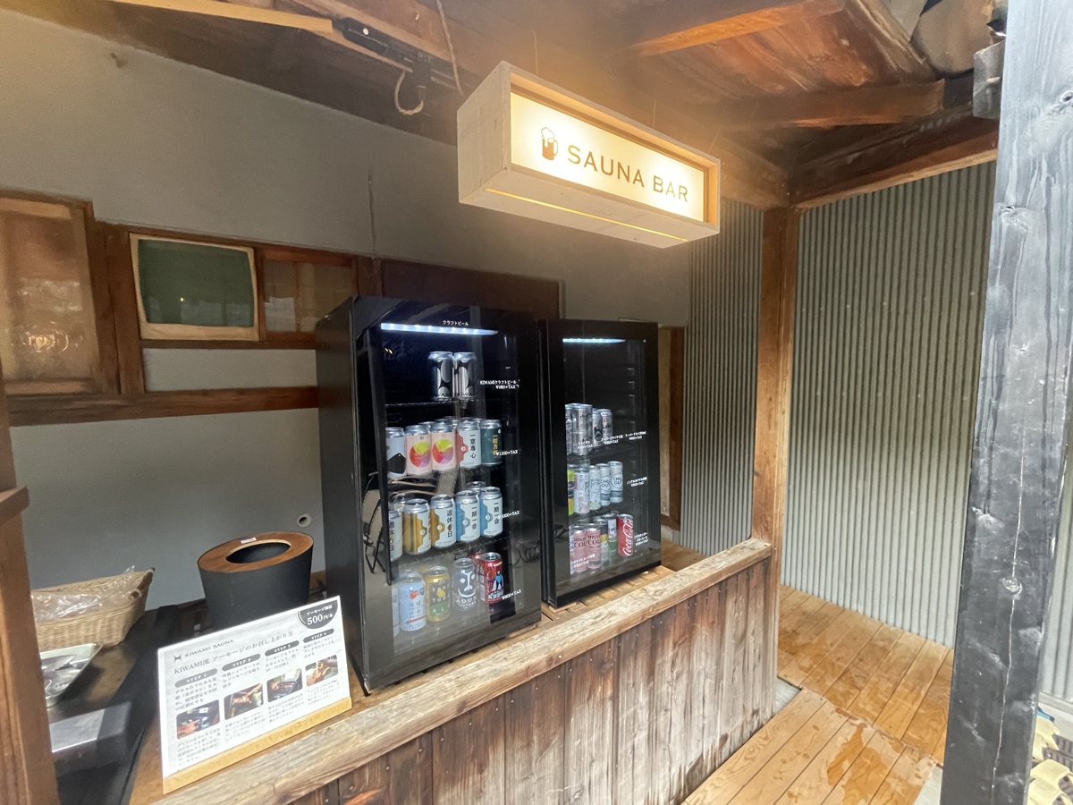 SAUNA BARと書かれた看板の下に並ぶドリンク冷蔵庫。サウナ後のドリンクをここから選べる